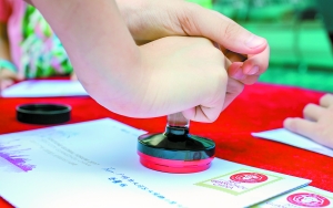 財富小信使”在信封上蓋郵戳。